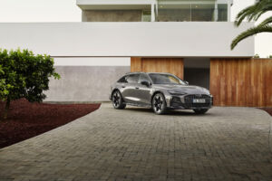 Audi A6 allroad (plateau grey metallic) front view in modern architecture (static shot).